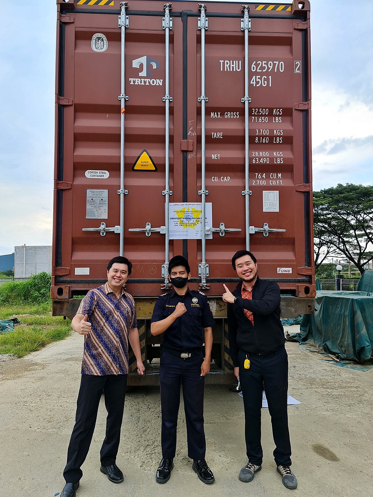 PT Glory Offset Press management with an Indonesian Customs officer at a sealed export container — customs-supervised bonded-zone shipment